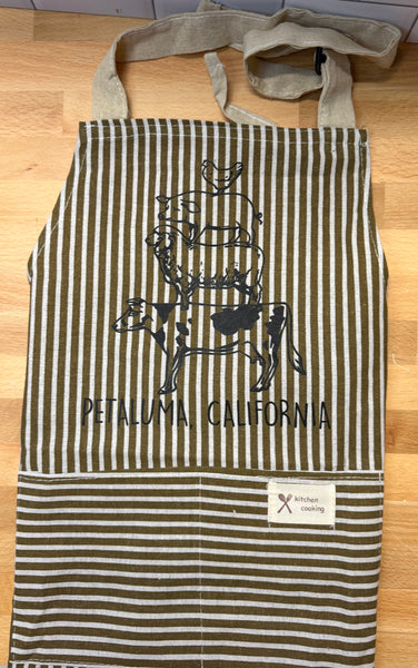 Striped apron with  Petaluma Animal Stack design and text on a wooden surface